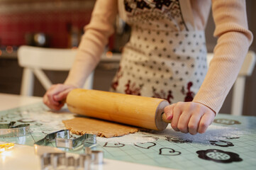 Children's hands mold Christmas cookies from gingerbread dough
