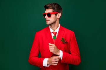 Portrait of attractive content fashionable guy dandy wearing classy suit fixing button isolated...