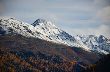 Davos mountain landscape in beautiful autumn. Snow on the mountain peaks and larch forests in the valley. Sentisch Horn. High quality photo
