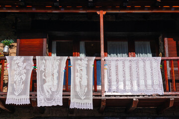 Manteleria bordada estendida en balcon en el pueblo de Rupit. Catalunya