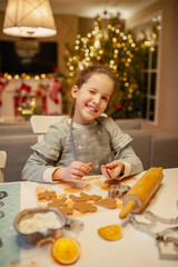 Girl preparing Christmas cookies at home in the kitchen