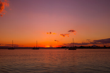 Fototapeta na wymiar Krajobraz morski. Widok z zachodem słońca i łódkami na morzu na greckiej wyspie Evia