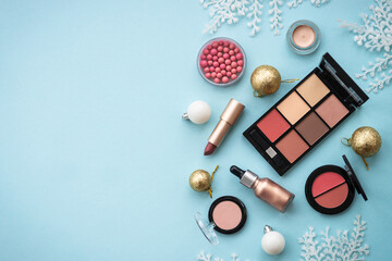 Winter cosmetic with holiday decorations on blue.