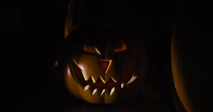 Halloween pumpkin in the dark. Flicker spotlight over the subject. Steady static shot 4k 12-bit footage.