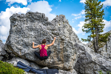 Sporty woman climbs on boulder problem in the afternoon. Falzarego pass, Dolomites, South Tirol,...