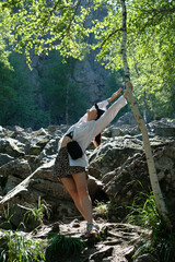 Girl tourist posing against the background of stones, rocks, nature. Day, forest.