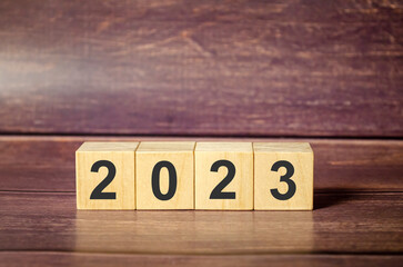 2023 word on wooden block and wooden background