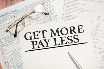 Get more pay less words on tax forms and pen on wooden background