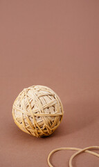 Yellow rubber band ball on brown light background