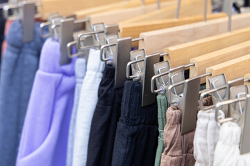 A shopping rank filled with clothes, pants, sports clothes. Bunch of clothes of different colors for sale. Cheep clothing and fast fashion theme