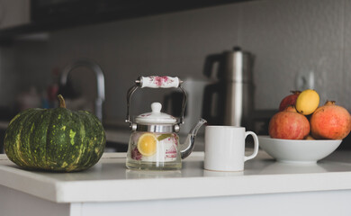 white Mug Mockup. A single white sublimation printable empty mug in the modern kitchen with fresh fruits and hot lemon drinks and single pumpkin. Unbranded cup mockup available to all cup sellers.