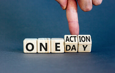 One day and action symbol. Concept words One day and One action on wooden cubes. Businessman hand. Beautiful grey table grey background. Business One day and action concept. Copy space.