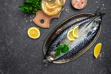 scomber, marinated mackerel or herring fish with salt, lemon and spices on a dark background....