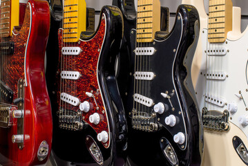 Electric guitars of different colors close-up. Cases of several electric guitars