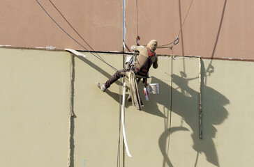 Climber builder closes the seams in a residential building at a height.