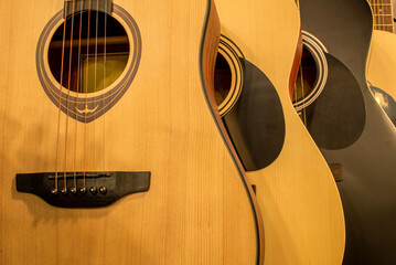 Acoustic guitars hang in a row in a music store. Guitars close-up
