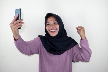 Portrait photo of young beautiful Asian woman feeling happy or surprise shock and holding smart phone isolated on white background