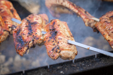 Grilled lamb ribs on a charcoal grill. Shashlik of lamb ribs. Meat on skewers. Meat on the bone. Street food. Meat barbecue. Outdoor cooking