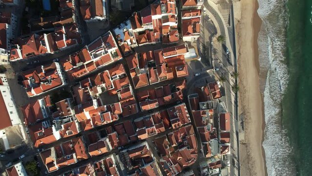 Top down aerial view of historic centre of Sesimbra, Setubal, Portugal on the Atlantic Coast with waves crashing