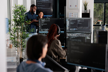 Software programmers discussing about algorithms on big screen and laptop, analyzing html code...