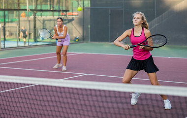 Woman tennis player training on court. Woman using racket to hit ball.