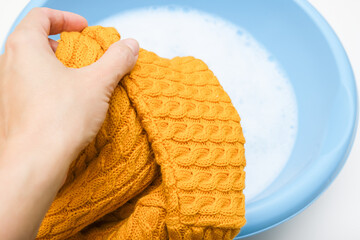 Hand washing of delicate woolen knitted clothes, sweaters concept, care of bright color clothes