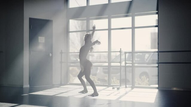 Woman running and jumping practicing contemporary dancing in dance studio / Lehi, Utah, United States