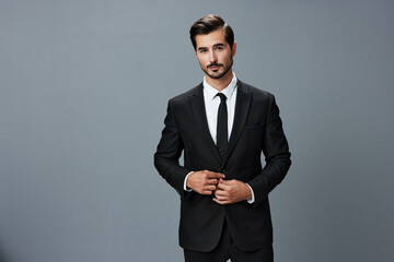 Obraz na płótnie Canvas Man confident businessman in a stylish suit with jacket tie and white shirt on a gray background portrait. The concept of young businesses and startups