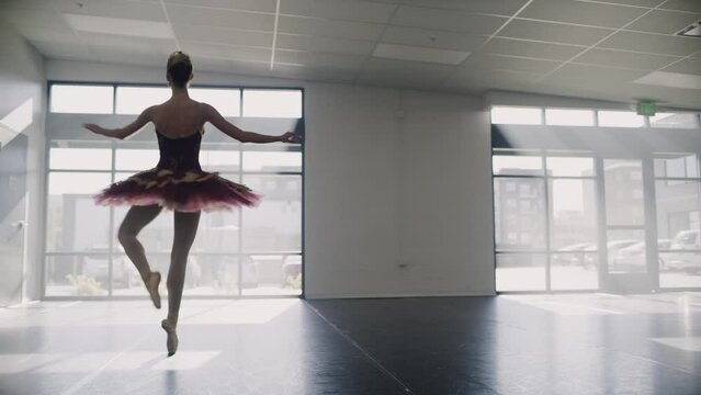 Tracking shot of ballerina practicing spinning in dance studio / Lehi, Utah, United States