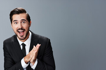 Man business surprised and happy rubbing hands portrait on gray background