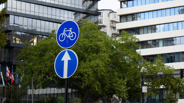 Photo of a round blue road sign with a bicycle. Road sign with an arrow up. Bike lane sign. Comfortable urban environment in the Georgian city of Tbilisi. The concept of caring for citizens of Georgia