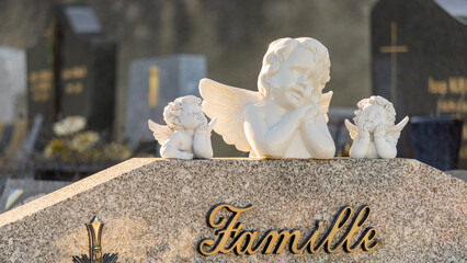 Statues of three cherubs, close-up, on a tombstone