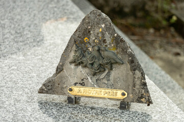 Funerary plaque in triangular stone decorated with birds, with the inscription: 