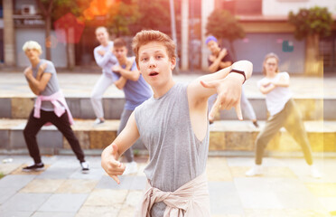 Portrait of teenager boy performing hip hop at city street