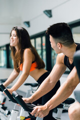 A young couple on cycling machine working out together