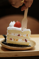 Close up of delicious fruit cake with strawberry and cream