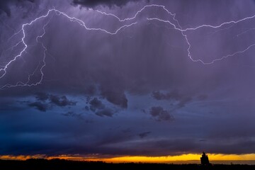 Lightning strikes above the clouds of a prairie sunset