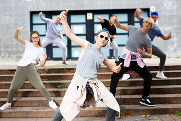 Teenagers boy and girls performing hip hop at city street