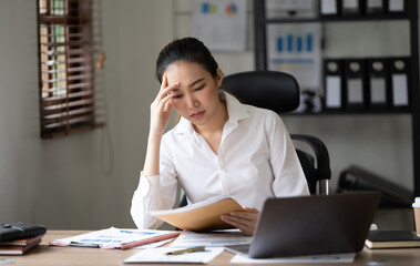 young business woman holding doccument paper working in office with laptop on wooden table
