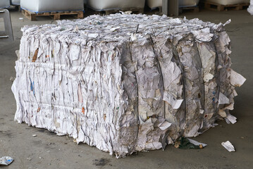 Pressed recycling paper on floor at waste processing plant