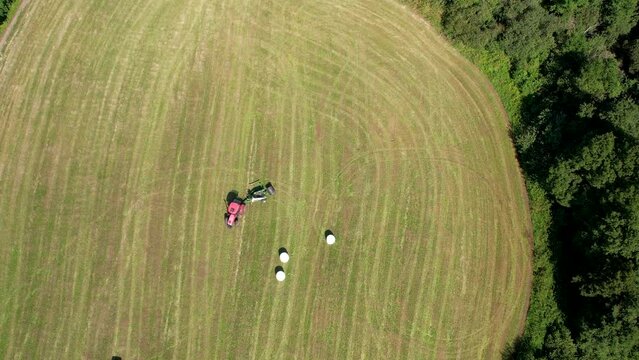 Aerial Birds Eye View Of Tractor Turning Around On Green Field In Chmielno