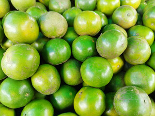 Green Orange, Tropical Fruits Background. Green Orange in store Farmer's Market Organic.