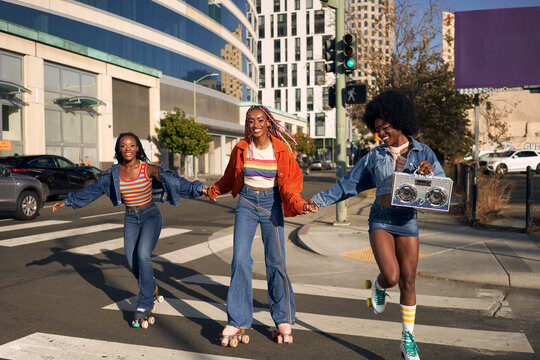 Portrait of young friend group rollerskating together in the city smiling 
