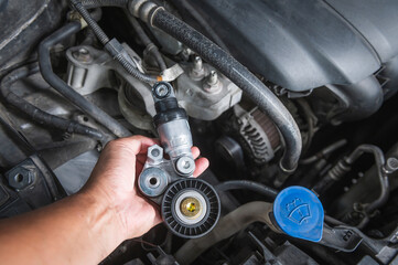 Close-up of automotive drive belt tensioner and pulley.