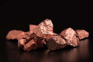 Ingots of pure copper or pink gold on a black background. - obrazy, fototapety, plakaty