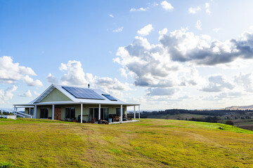 House in the country on a hilltop with solar panels for off grid sustainable living