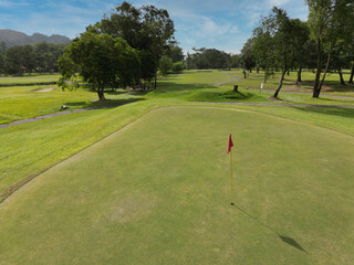 Fototapeta na wymiar View of golf course fairway from the green with a hole and a flag