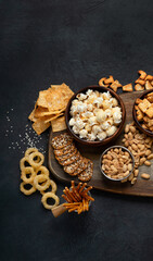 Obraz na płótnie Canvas Assortment of salty snacks on dark background.