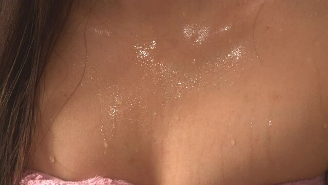 CLOSE UP View of young woman's chest covered in sweat drops during sauna session. Woman in hot sauna for detoxification, stress relief and strengthening of the immune system in cold winter months.