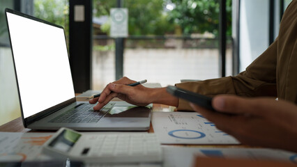 Fototapeta premium Asian businessman checking information while working with satisfaction on his laptop.